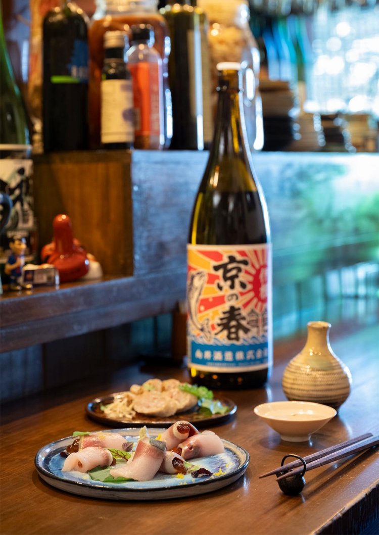 伊根ぶり燻製すじこ巻き1180円（手前）、発酵ソーセージのグリル880円（奥）。「京の春」は、ぶりと同じ京都・伊根の酒。