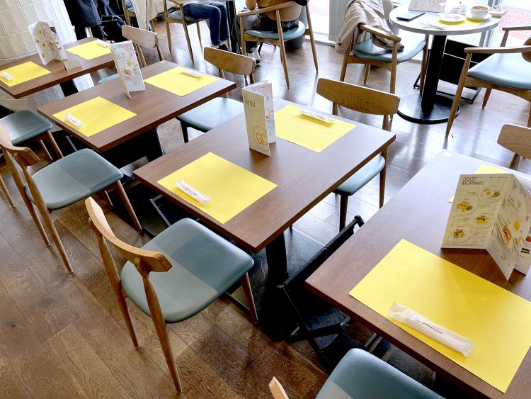 自然光がたっぷり入る明るい店内。イエローのランチョンマットが木目に映える。