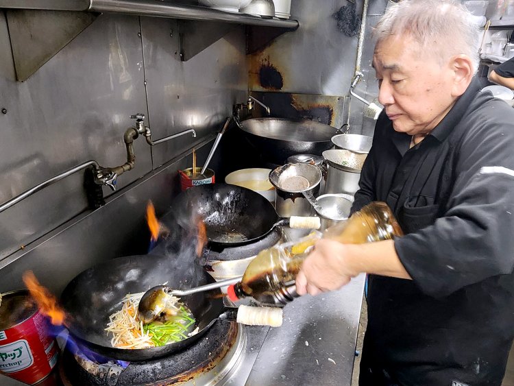 松夫さんは中華鍋をあおりアタマを用意。松夫さんと憲曉さんのあうんの呼吸で調理が進む。