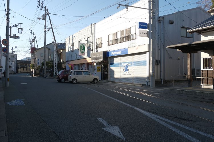 文具店の目の前に軌道があり、その先で終点となっている。電車が折り返しできる構造なのだが、軽自動車が駐車しているので機能していないと分かる。かつては文具店の前で電車が降り返していたのか。