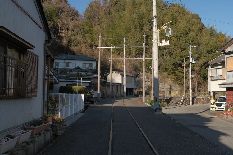 振り返って前方を見る。右側が生活道路で軌道跡との段差からそこそこの上り勾配だと分かる。家々の軒先に軌道跡。うらやましい光景だ。