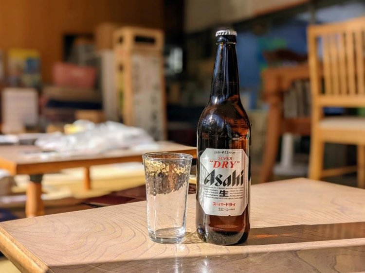 冷えた瓶ビールとそれを待つグラス。