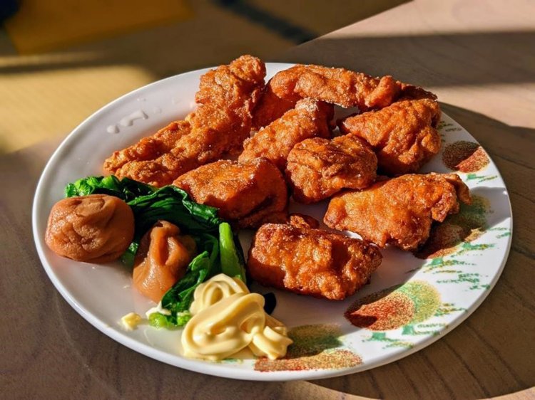 大皿に敷き詰められた「から揚げ」と、なぜか添えられている梅干し。