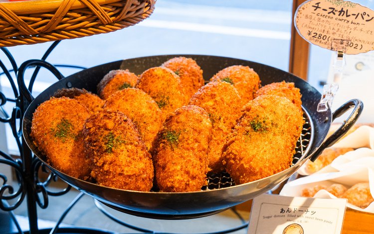 朝いちばんから並ぶチーズカレーパン302円。