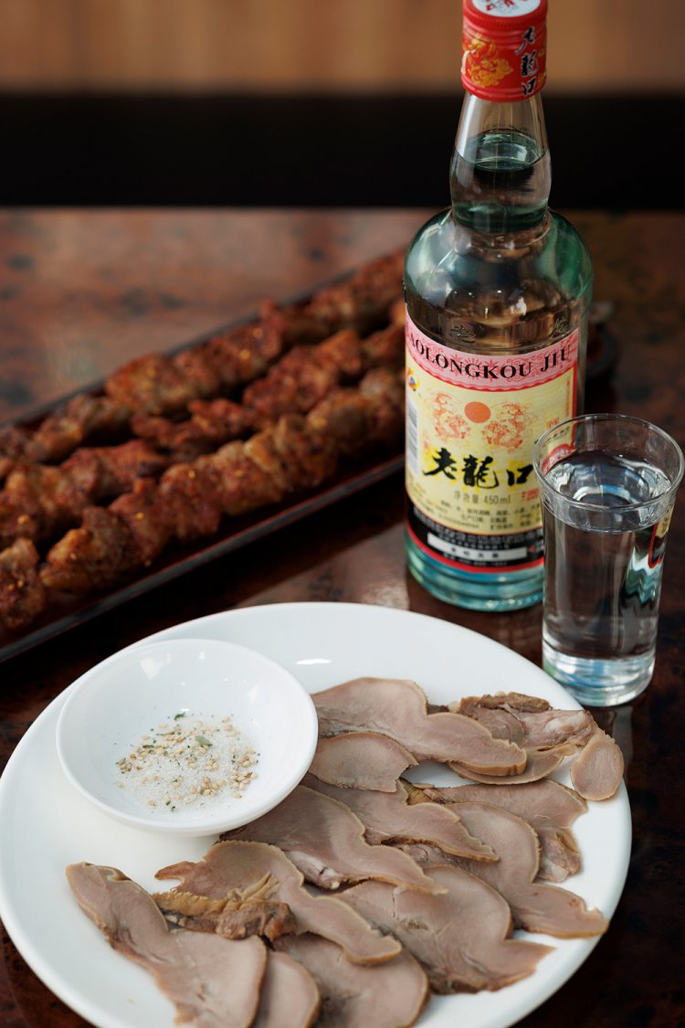 羊舌の塩コショウ1080円など羊料理がたくさん。多くの人が注文する、特大ラム肉の串焼き1080円（1本）にかぶりつき、老龍口42度500円（グラス）をくいっと！