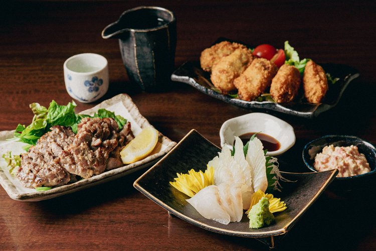 右手前は平目の刺し身890円、左は徳之島産の島豚肉ほほ肉塩こうじ焼き780円、右奥はカキフライ680円、「月山」1合1100円。