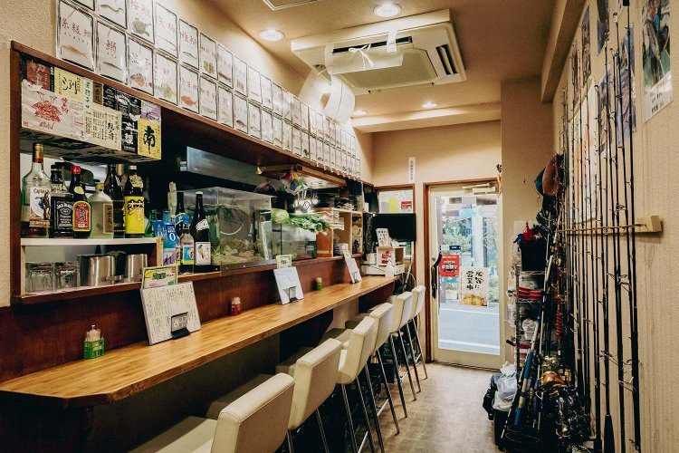 釣り道具が並ぶ店内。カウンター席の奥にテーブル席もあり。