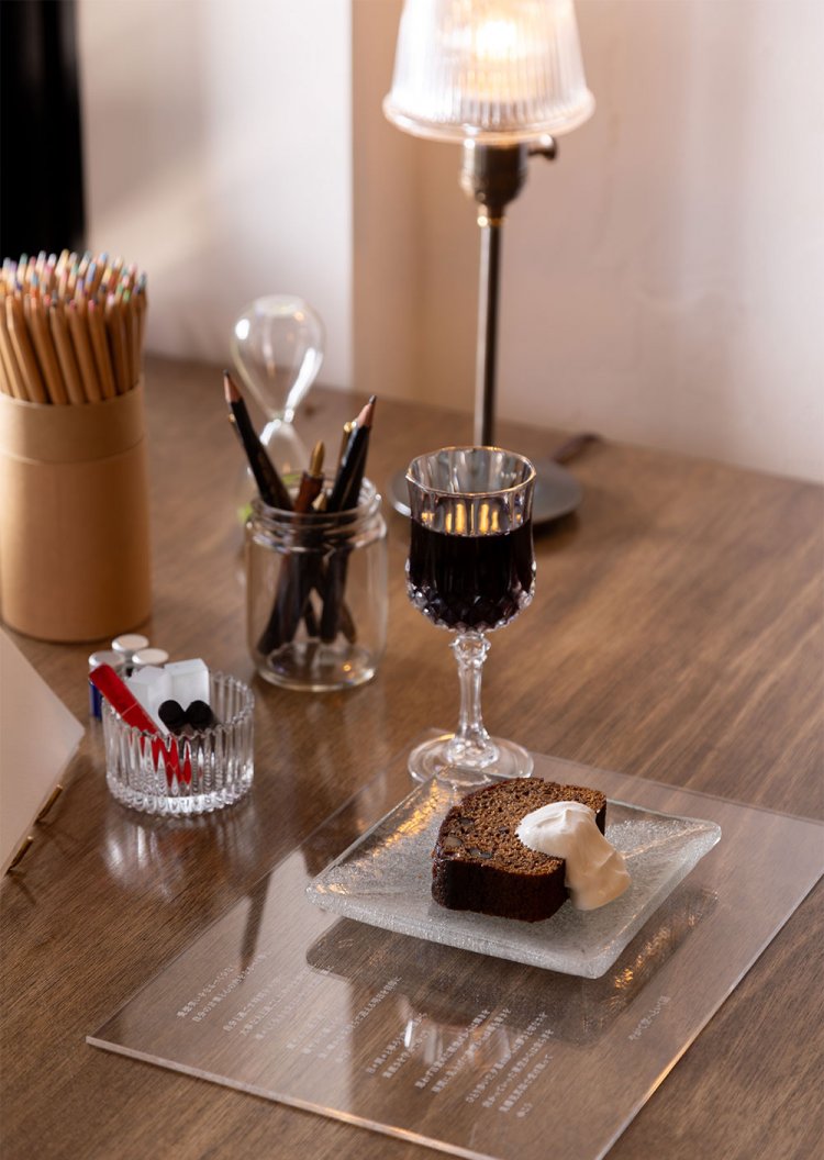 アクリル板に刻まれた詩的な読み物と国産ブドウのワイン、コクのあるバナナケーキをセットにしたA CUP OF LETTERは1430円～。