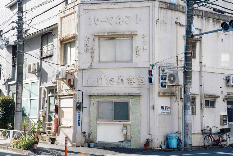 外壁にメニューを記した元美容室。レトロクラシックな建築だ。