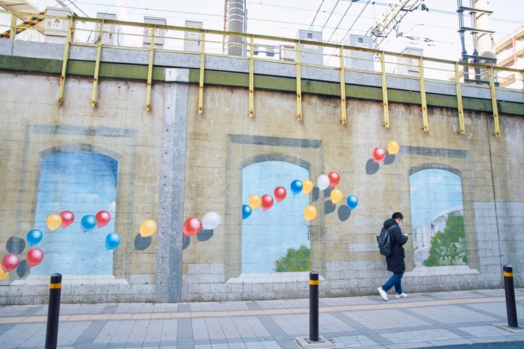 両国駅南東に描かれた高架壁画。通行人がアートの一部に溶け込むよう。