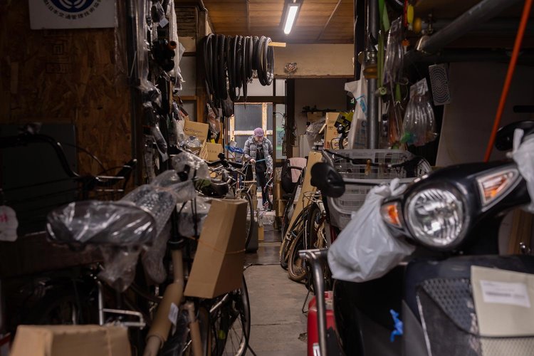 路地裏で自転車修理する『Repair Shopコクボ』。鰻の寝床の店は奥にも入り口が。