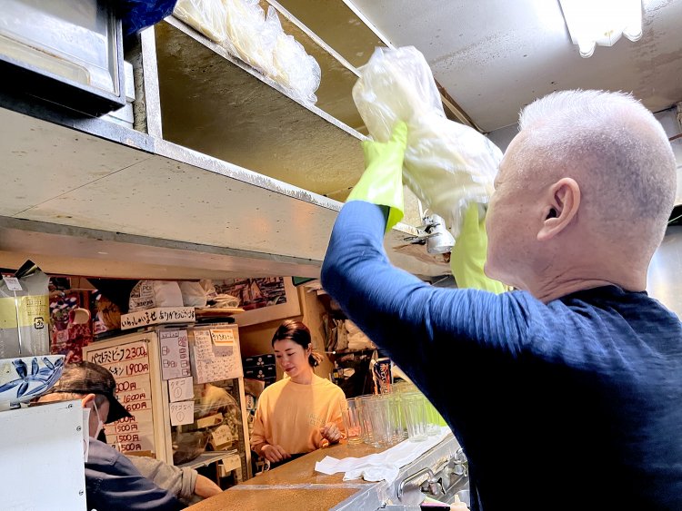 パンを棚にひとつずつ収納していく。あ、マスターはゴム手袋をしてるから熱くないんですね。