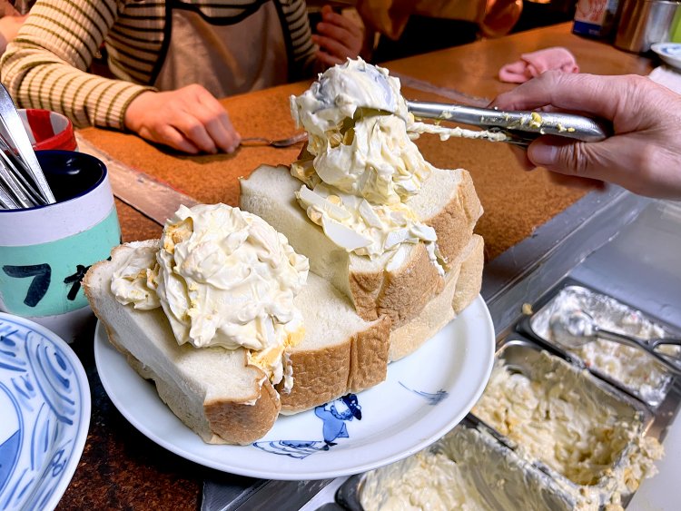 パンの間にたっぷりタマゴサラダが入り、さらに山盛りのタマゴサラダが上にドーンと乗る。