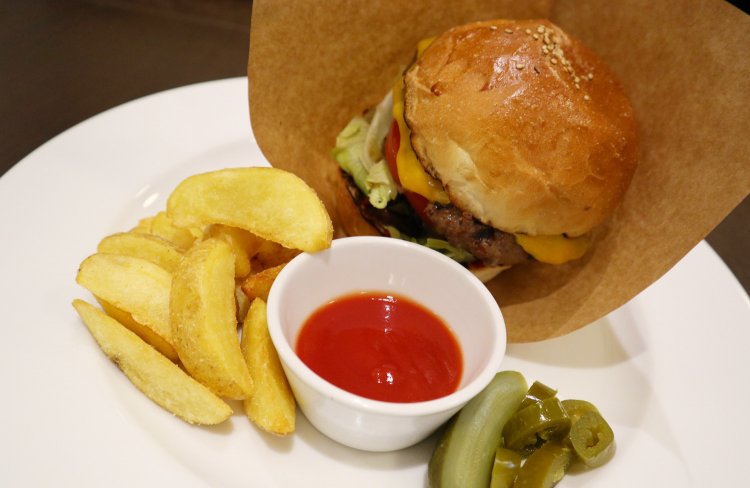 デカリーバーガー1350円。フライドポテトとケチャップ、ピクルスとハラペーニョ付き。