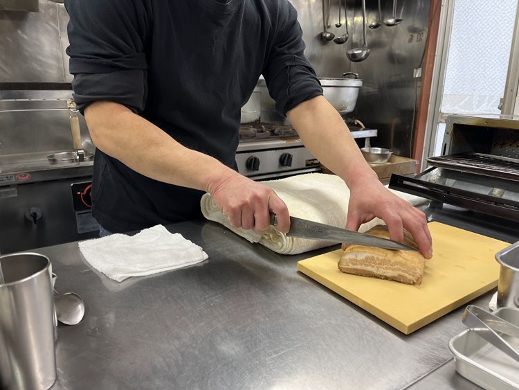 キッチンに立ち、チャーシューを切る。