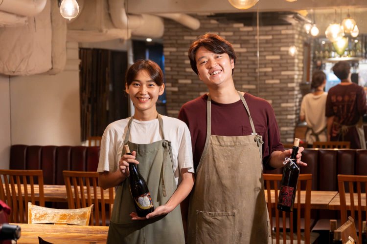 店主 小高直斗さん（右）とスタッフ 熊谷さゆさん。「20種以上のワインをグラスで楽しめます！」。