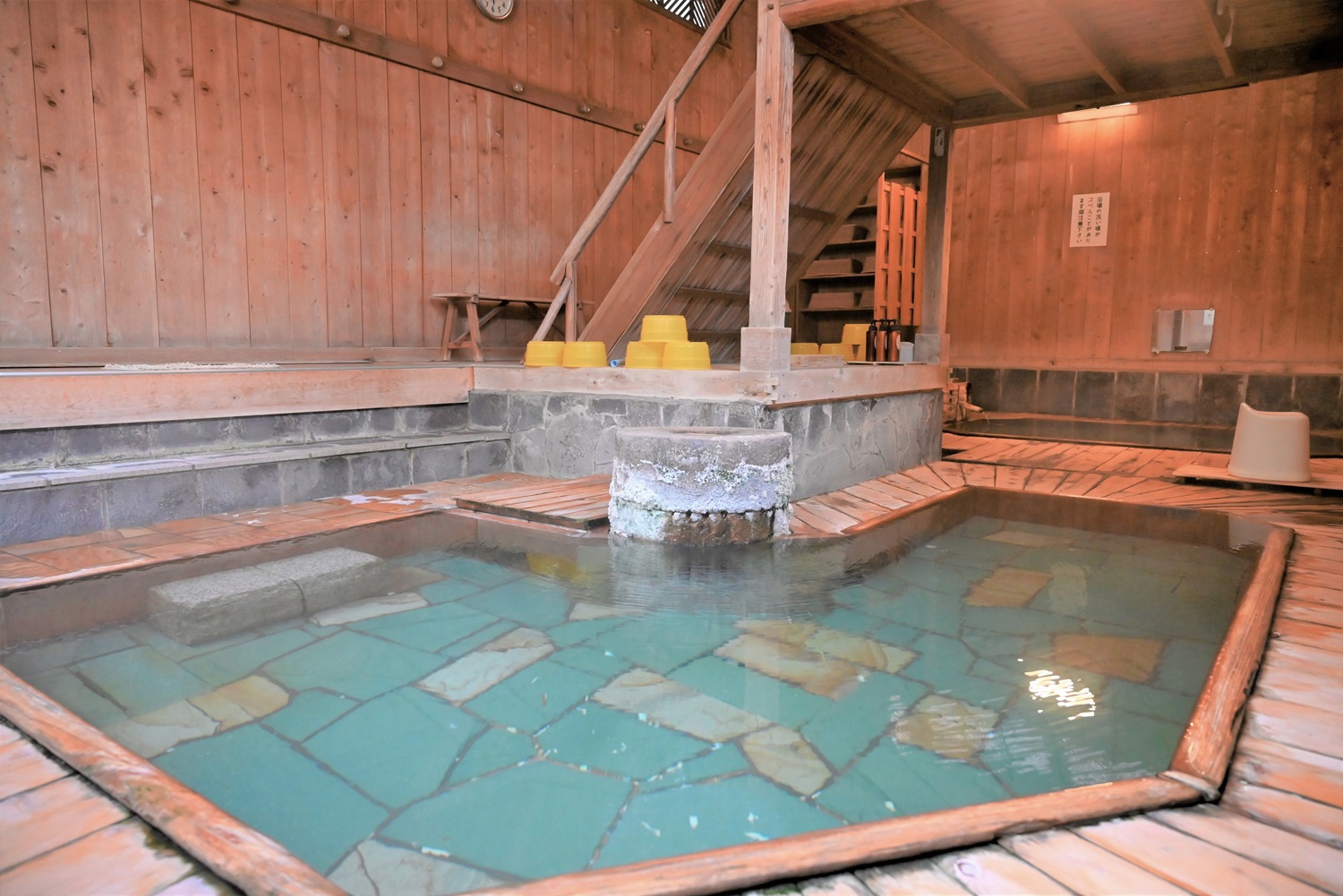 昭和レトロな趣がある混浴の大浴場は天井、壁、浴槽など総檜造り。2つの湯船があり、J字型の湯船にはモザイクタイルが敷かれている。