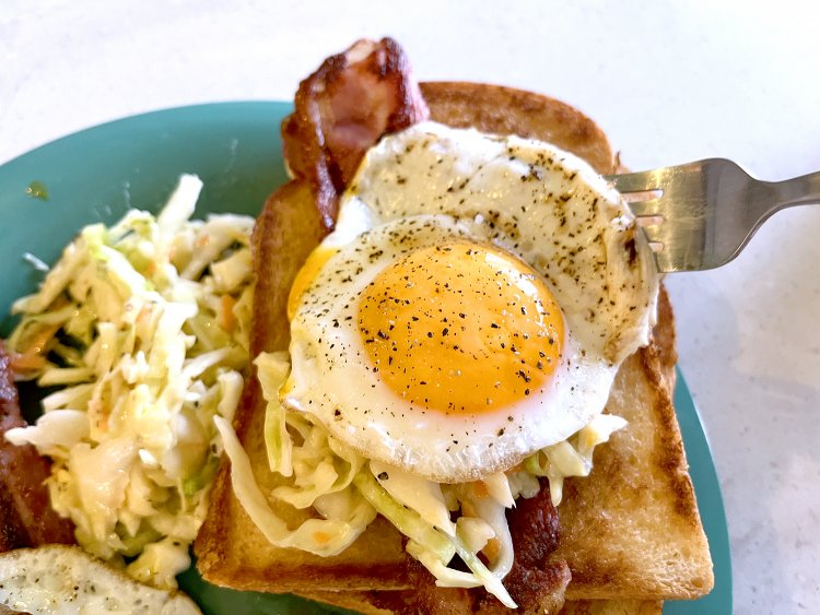 ベーコン1枚、コールスロー少々、目玉焼き1個を食パン2枚でサンド。これがこの日の筆者の食べ方だ！