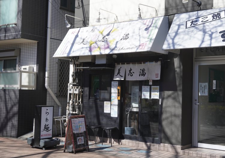 千川通り沿いに立ち、目の前は都営バスの車庫。