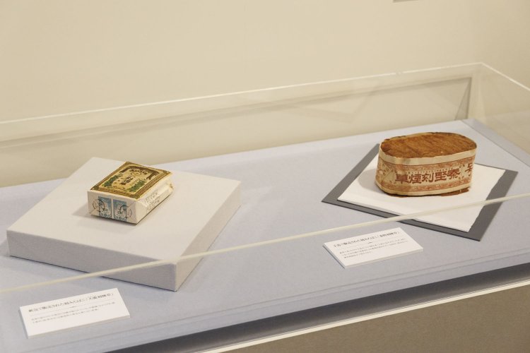 明治前期の刻みたばこパッケージ。右が帯だけで包んだもの。左はきっちり包み底面に印紙が貼られたパッケージ現物。