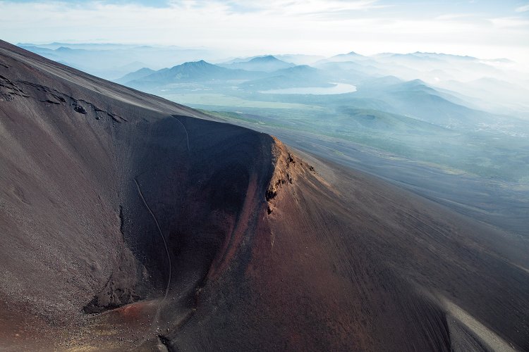 巨大な火口のエッジとなっている宝永山の向こうに、山中湖が見える。その奥が道志村、右奥に見えるのは丹沢の山々。