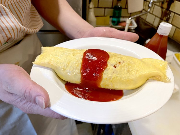 しっかり卵に火が通ったタイプのオムライス。ケチャップとのコントラストが最高〜！