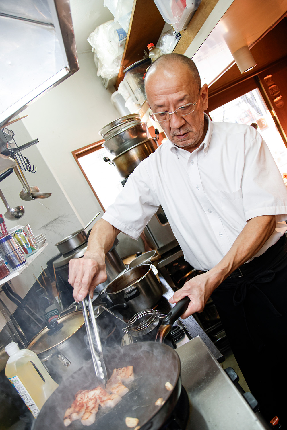鍋をふる金村さん。「元祖の味をぜひ食べに来てください」