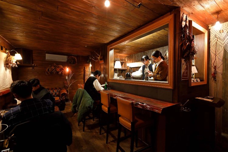 友人作の看板を頼りに階段を上がれば、山小屋風のひそやかな空間が待つ。