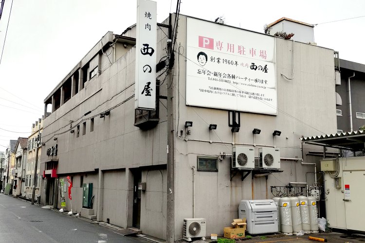 産業道路側から見た外観。建物の隣は駐車場になっている。8名以上の予約で送迎バスを利用可能。