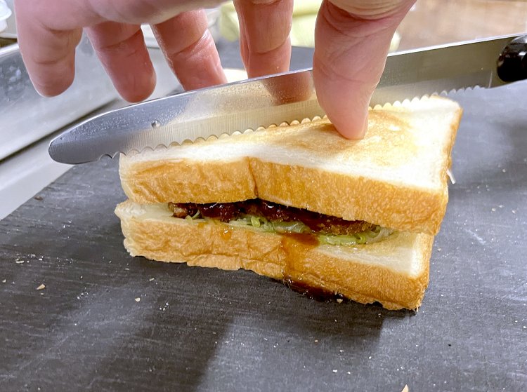 食パンを重ねたら軽くつぶして電動のパン用カッターでキレイにカットする。