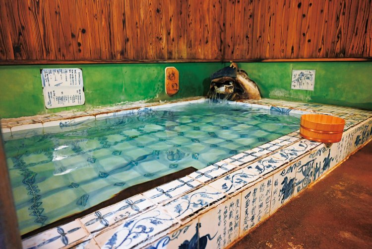 白磁のタイルに藍の染め付けで飛天や山水図などが描かれた「飛天の泉」。男女入れ替え制。