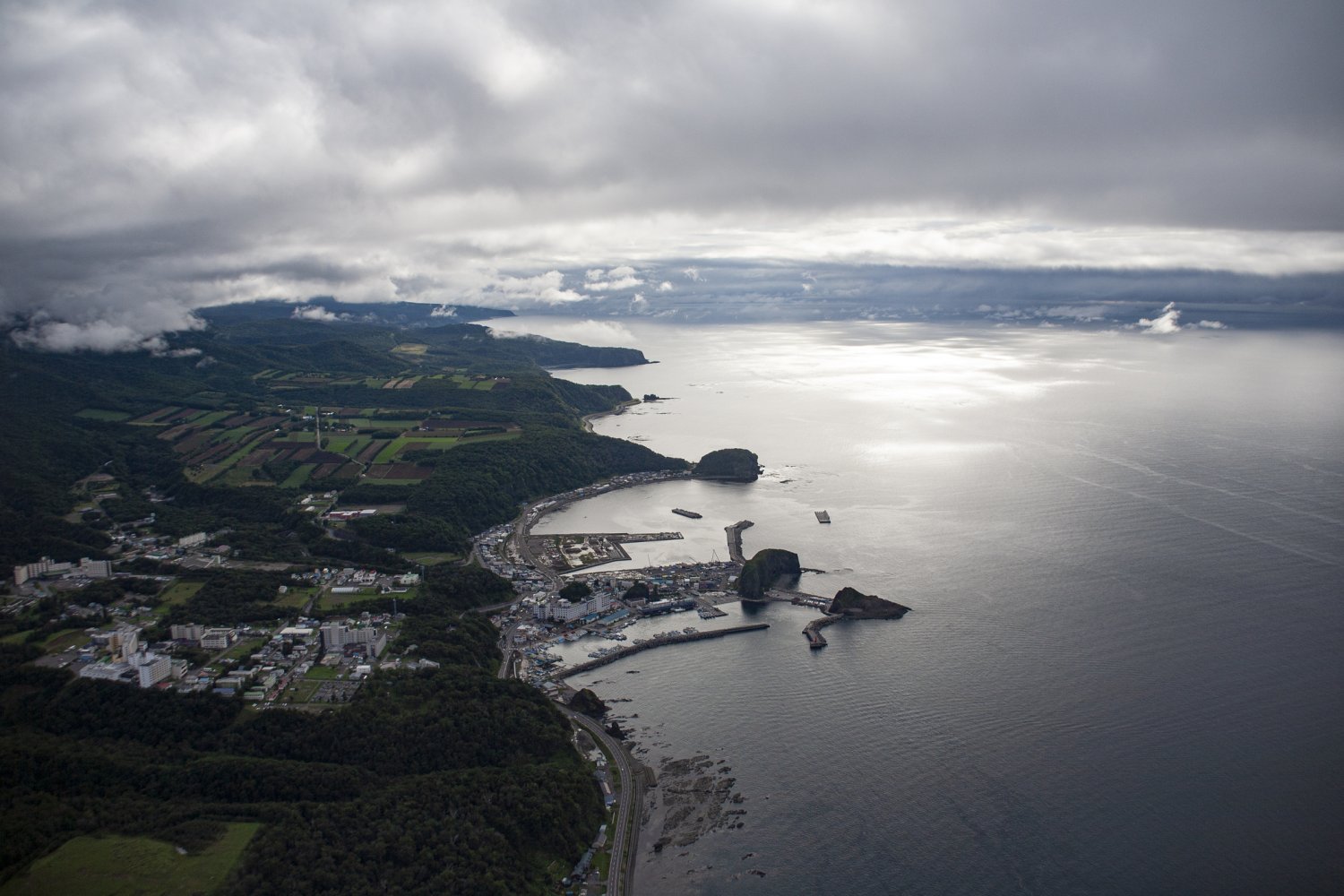 上空から見たウトロの町と漁港。オロンコ岩とカメ岩が特徴的。