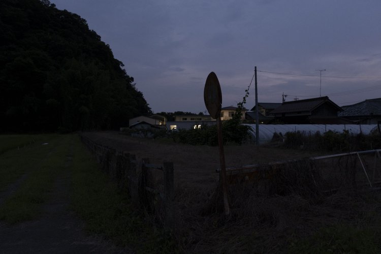 南側の雑木林の方向を見る。左手があぜ道で、敷地境界線に鉄道柵があるのだが、もう闇の中で分からない。2020年7月20日撮影。