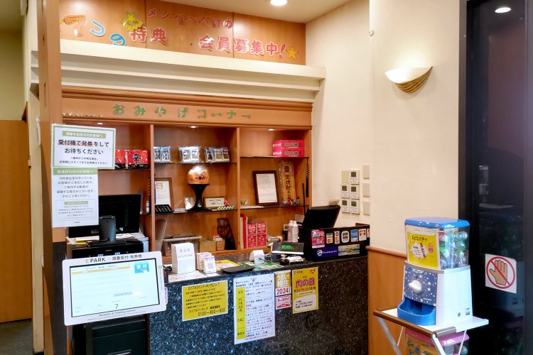 おみやげコーナーを兼ねたレジ。施設予約サービス『EPARK』の端末には、店内の混雑状況がリアルタイムで表示されている。