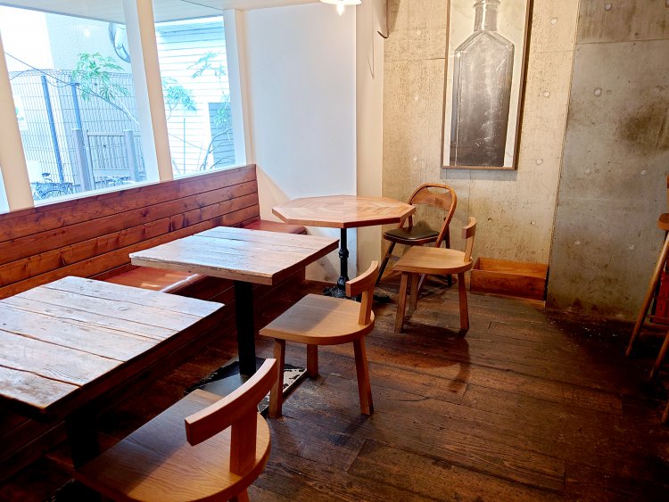 カウンター７席、テーブル8席の計18席。木のテーブルや椅子などぬくもりあふれる店内。