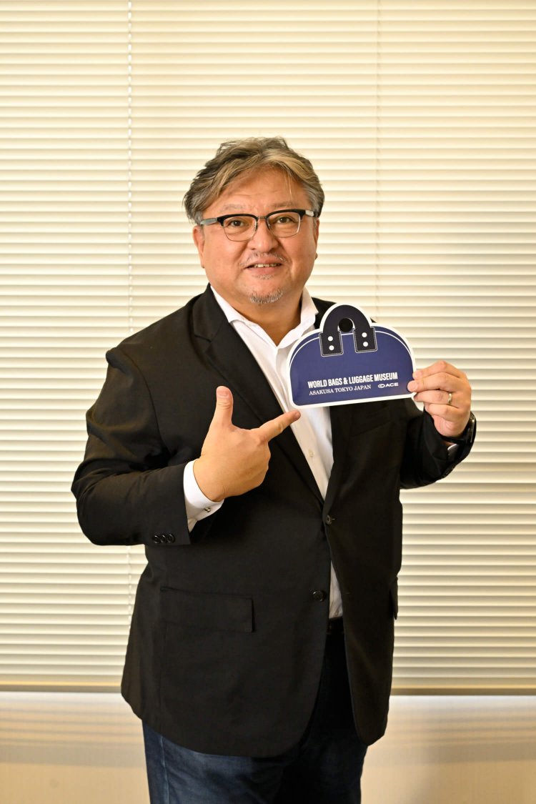 館長 難波敏史さん。「カバン型のオリジナルうちわも無料配布中です」。