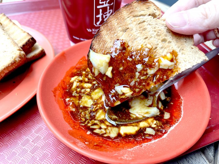 半熟卵にソイソースとホワイトペッパーをまぜ、カヤトーストにたっぷりつける。