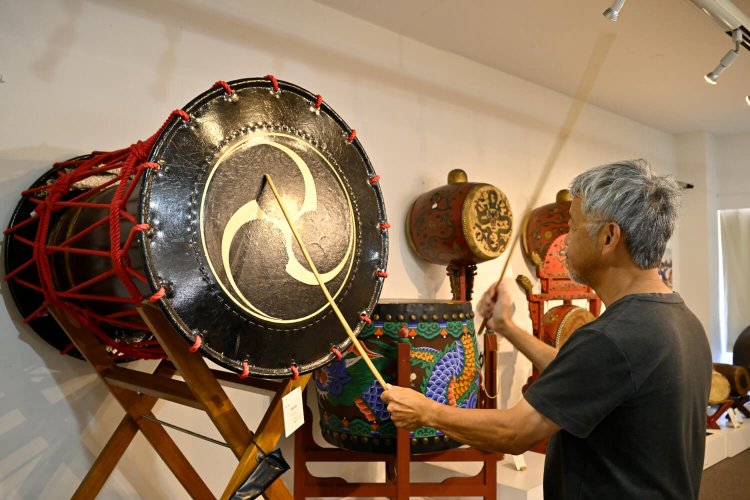 直径90㎝の黒い大締太鼓。説明書きに「♪」マークがある太鼓は叩けるぞ。