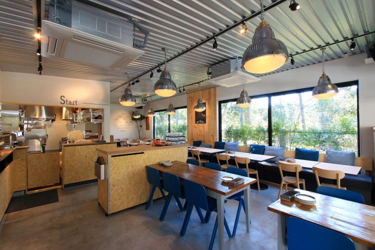 白壁に木目調が映える内装。大きな窓からは旧安田庭園が望める。（写真＝店舗提供）