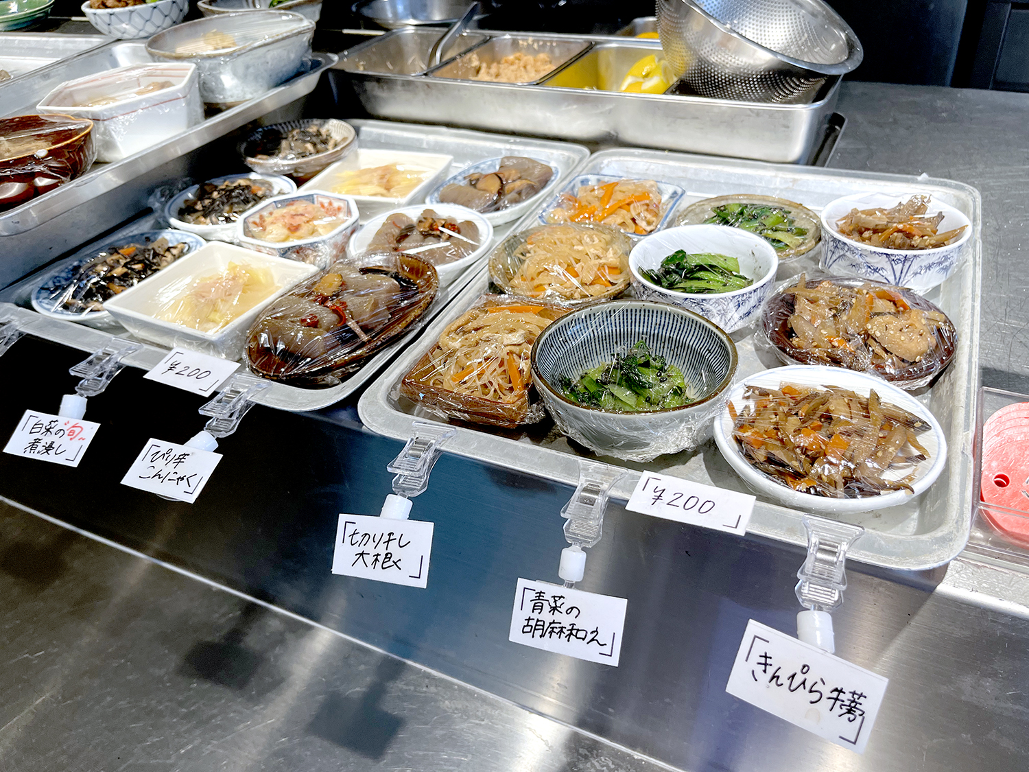 カウンターの上のお総菜は煮浸し、きんぴら、胡麻和えなど小鉢の定番が並び、オール200円。