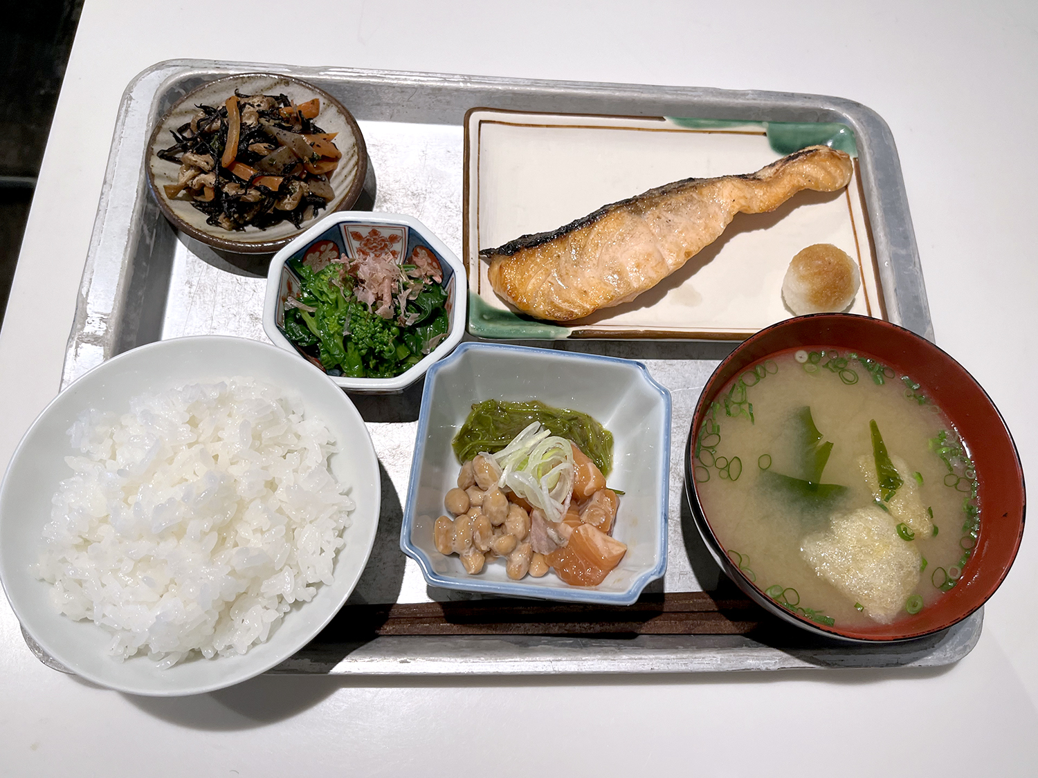 銀シャリ、味噌汁、焼き鮭、菜の花のおひたし、ひじきの紫蘇煮、漬けサーモンと納豆で合計1600円也。