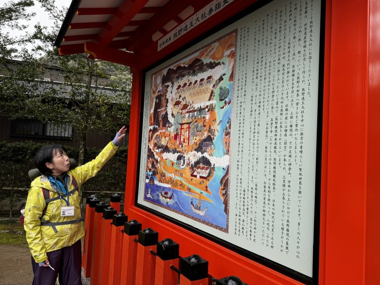 熊野速玉大社の境内で熊野曼荼羅（まんだら）の説明をするガイドの福田さん。