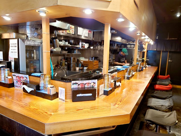 どの席からも厨房が見渡せるL字カウンター12席。カウンター下に収納スペースあり。