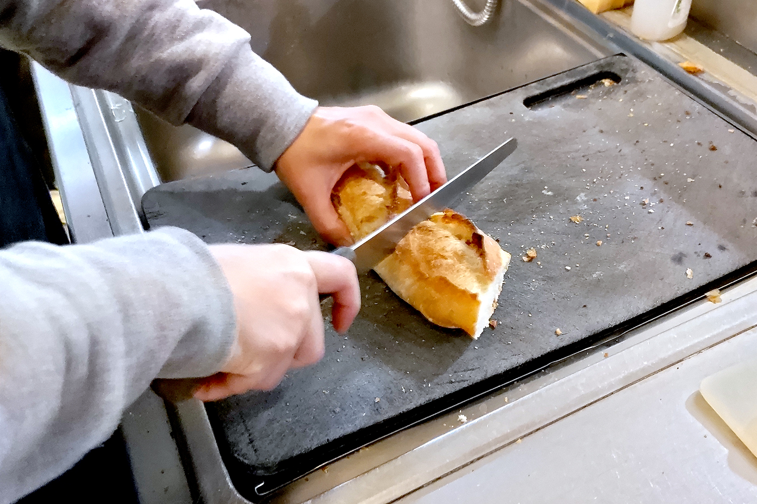 フランスパンを切り分けるところ。カットする際の心地よい音から、生地のハードな感触が伝わってくる。