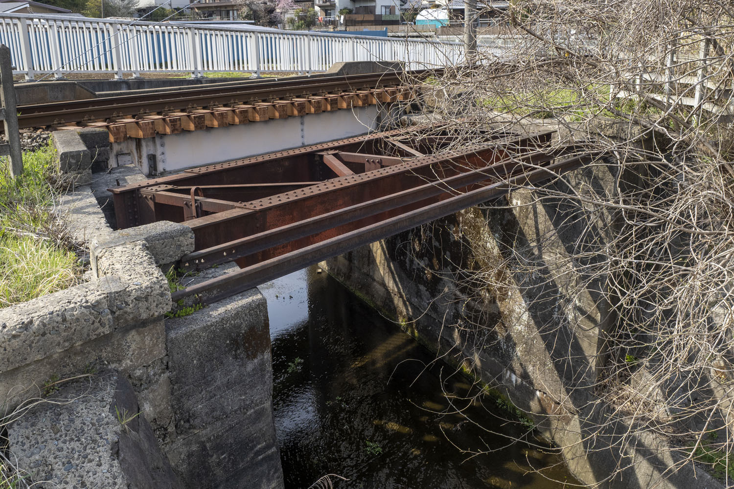 橋の全景。橋台は軍用線のときに造られたと推察する。桁と並んで2本の古レールがあるのは、職員用の渡り板だろうか。米軍撮影の空中写真では判別できなかった。
