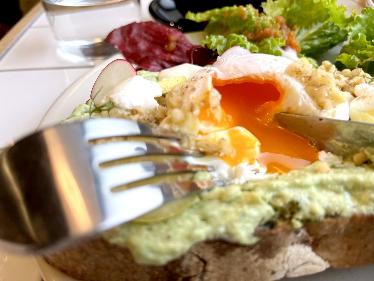 ポーチドエッグにナイフを入れると卵の黄身が流れ出す。