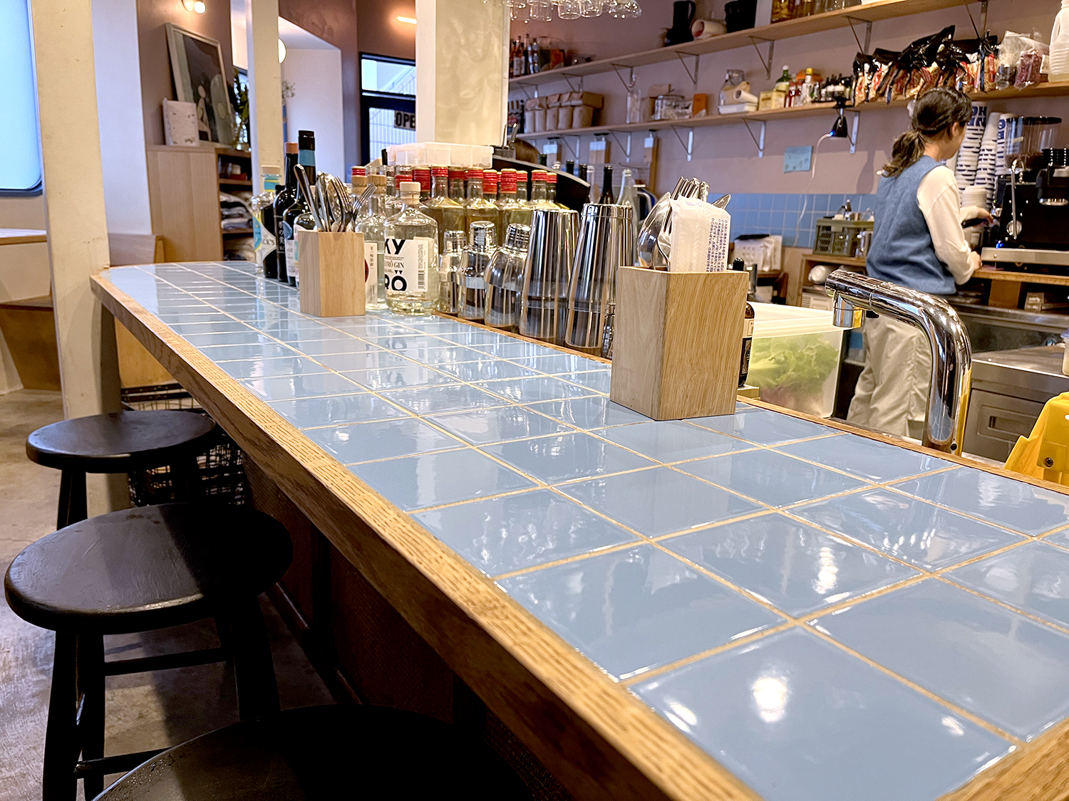 カウンターの青いタイルやテーブルの白いタイルは、昭和の頃のキッチンで一般的に使われていたものだそう。店内の差し色にもなっている。