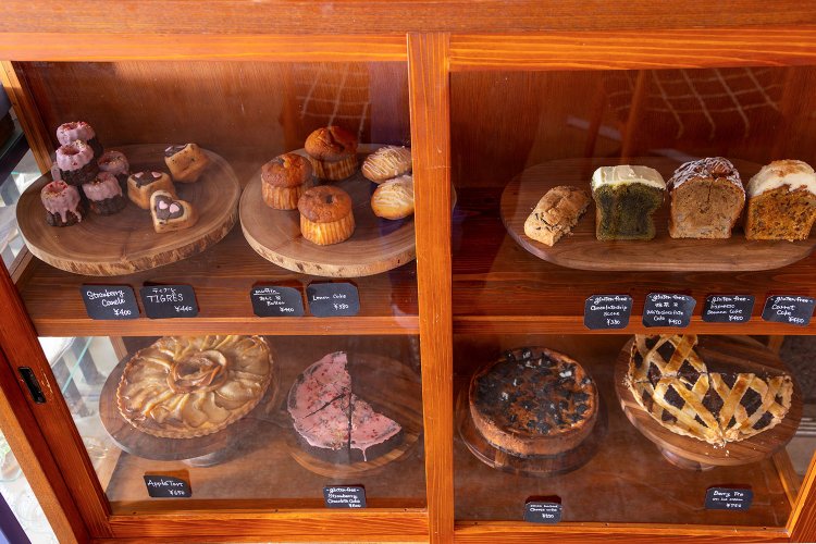 レジ脇の特注木製ケースに焼き菓子を陳列。中にはグルテンフリー、季節限定も。下にレコードが収納され、オールディーズが流れる。
