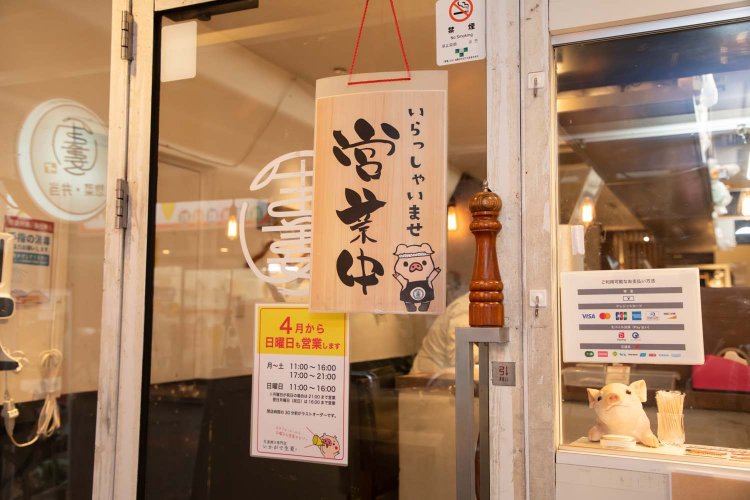 ガラス張りのエントランス。かわいらしい豚のマスコットがお出迎え。