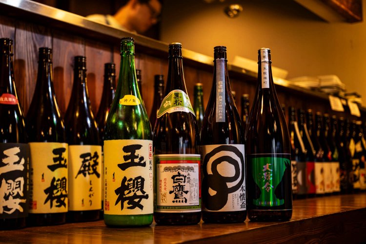 『えんらい』店内奥のカウンターには燗向けの酒がびっしり。純米酒ファンに人気の「玉櫻」のような小さい酒蔵の酒から大手の「白鷹」まで多彩なラインアップが揃う。